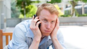 A man annoyed waiting on hold